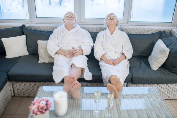 Casal maduro em vestes brancas relaxando em um centro de spa e se sentindo confortável — Fotografia de Stock