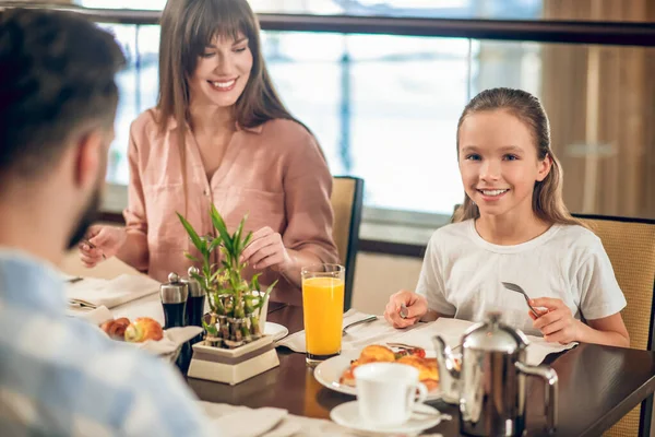 Young family sitting at the table in the restaurant — Stock Photo, Image