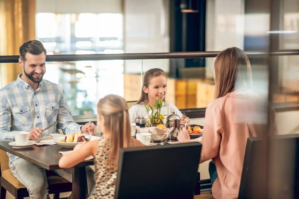 Família feliz sentada à mesa no restaurante — Fotografia de Stock