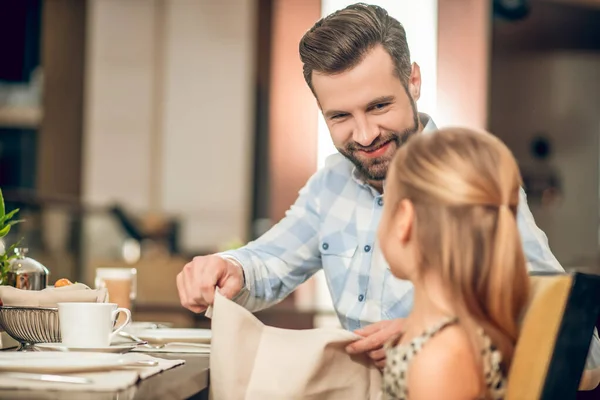 Pappa äter frukost med sin dotter och ser glad ut — Stockfoto