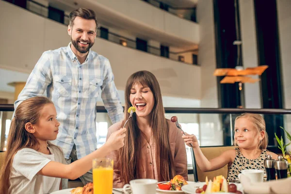 식탁에 앉아서 즐거운 시간을 보내고 있는 미소짓는 가족 — 스톡 사진