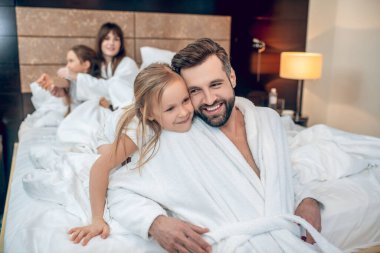 Genç sakallı adam kızıyla oynarken mutlu görünüyor.