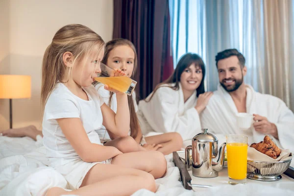 Ouders en kinderen ontbijten en kijken tevreden — Stockfoto