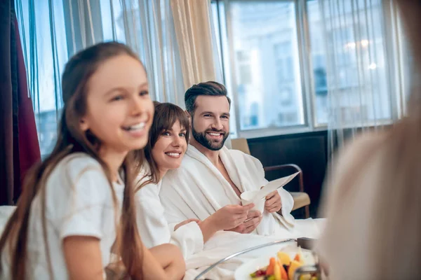 Padres e hijos desayunando y luciendo satisfechos —  Fotos de Stock