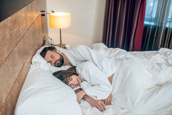 Couple in white robes sleeping and looking peaceful