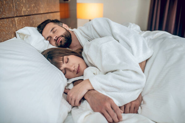 Couple in white robes sleeping and looking peaceful