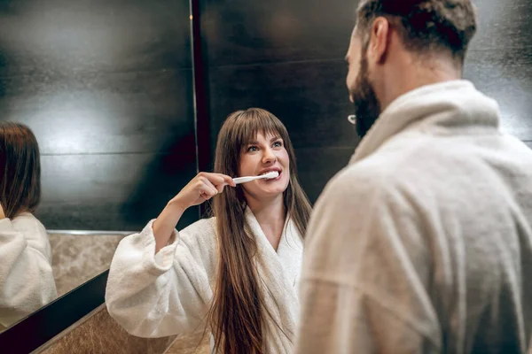 Banyo cüppeli genç bir çift birlikte diş fırçalıyorlar. — Stok fotoğraf