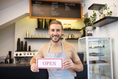 Cafe 'de misafir çağıran memnun bir adam.