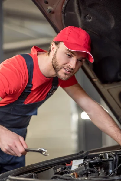 Man looking into open hood of car — Stock Photo, Image