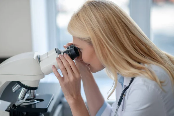 Primer plano de la mujer que trabaja detrás del microscopio — Foto de Stock