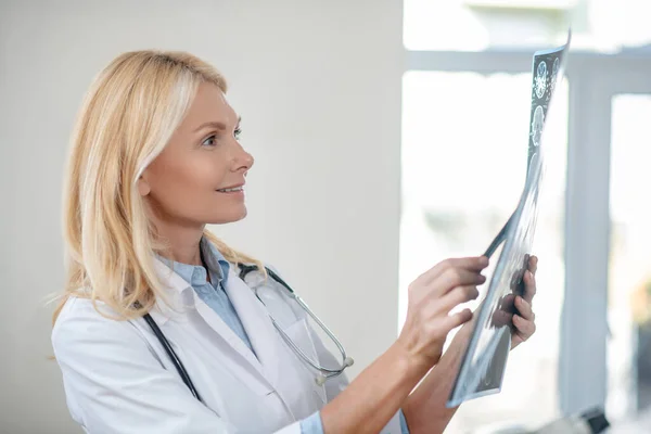 A következő profilja: joyful female doctor considering MRT scan — Stock Fotó