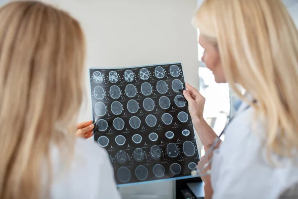Dos médicos de pie con la espalda examinando la tomografía computarizada — Foto de Stock