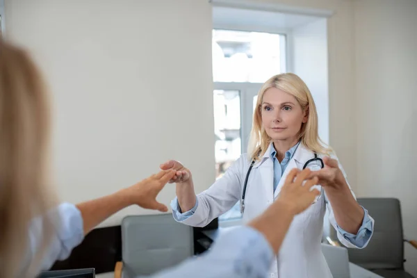 Doktor kollarını uzatmış hastanın parmaklarına dokunuyor. — Stok fotoğraf