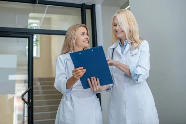 Två glada kollegor läkare som kommunicerar om arbetsfrågor — Stockfoto