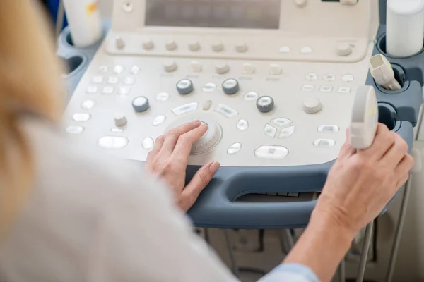 Doctor sentado cerca de la máquina de ultrasonido — Foto de Stock