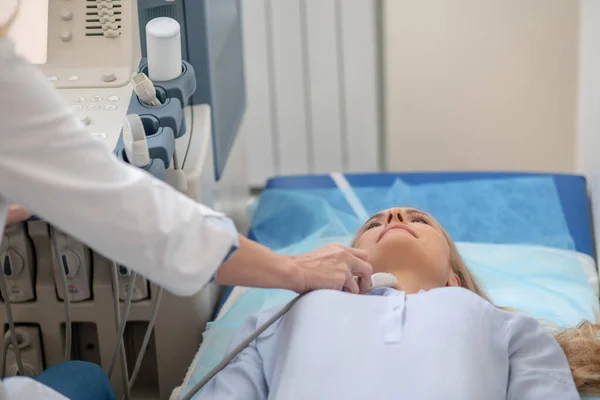 Médico que realiza ecografía del cuello de los pacientes — Foto de Stock