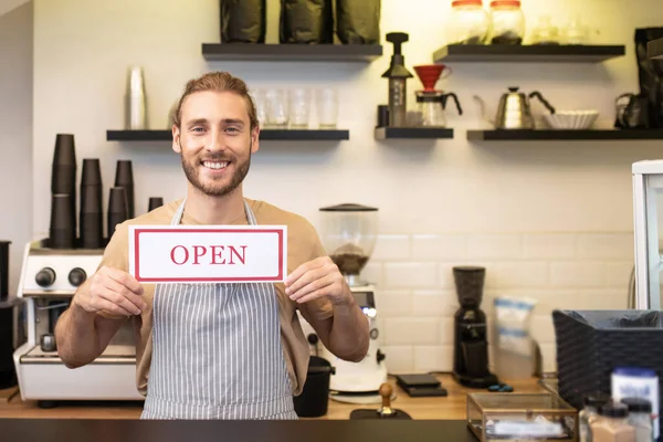 Uomo felice vicino bancone bar con segno aperto — Foto Stock