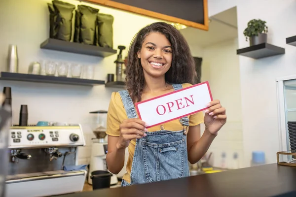 Frau am Tresen mit Schild mit der Aufschrift "offen" — Stockfoto