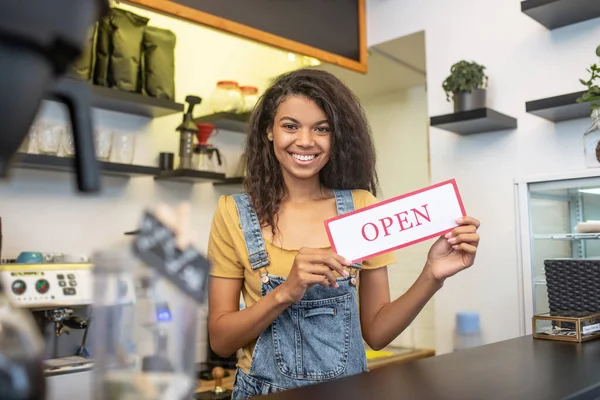 Χαμογελαστή κοπέλα προσκαλεί επισκέπτες στο άνοιγμα cafe — Φωτογραφία Αρχείου