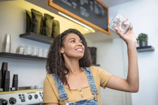 Mujer sonriente revisando vidrio para la calidad de la limpieza —  Fotos de Stock