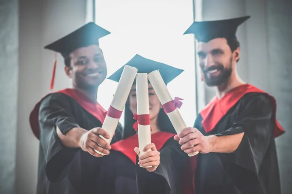 Graduados em morteiros que parecem felizes e alegres — Fotografia de Stock