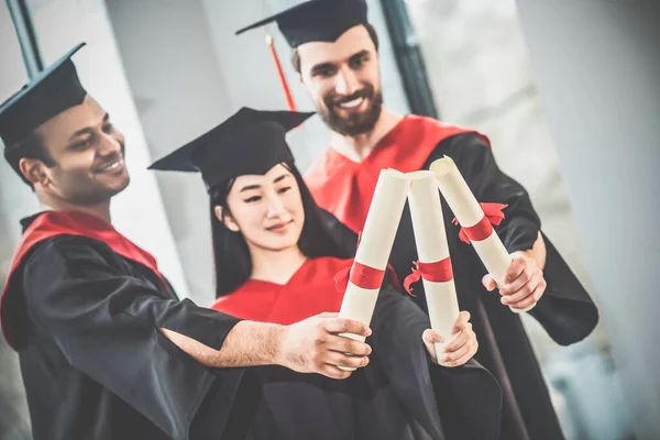 Young people in mortarboards looking happy and joyful — Stock Photo, Image