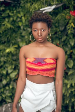 Koyu tenli, beyaz şortlu genç bir kadın.