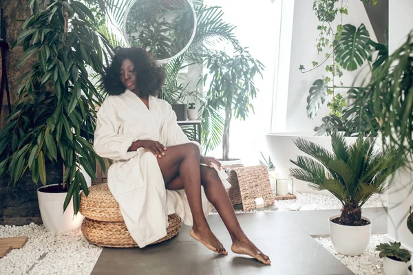 Banyoda beyaz bornozlu Afro-Amerikan güzel kadın.