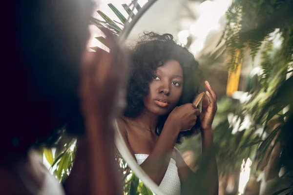 Mulher de pele escura encantadora entre as plantas verdes — Fotografia de Stock