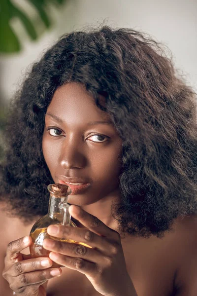 Close-up de uma bela jovem mulher cheirando um óleo essencial — Fotografia de Stock