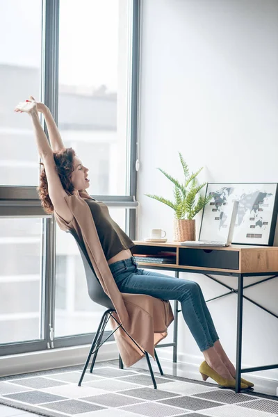 Mujer morena sentada con teléfono en las manos — Foto de Stock