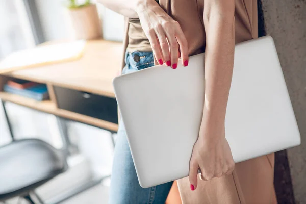 Imagen de cerca de manos femeninas sosteniendo una computadora portátil — Foto de Stock