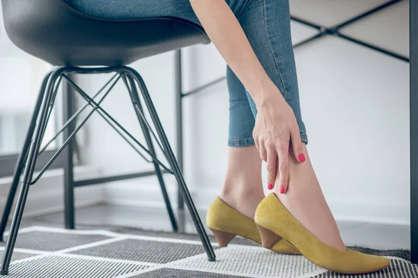 Mujer tocando sus pies doloridos en un zapato nuevo — Foto de Stock