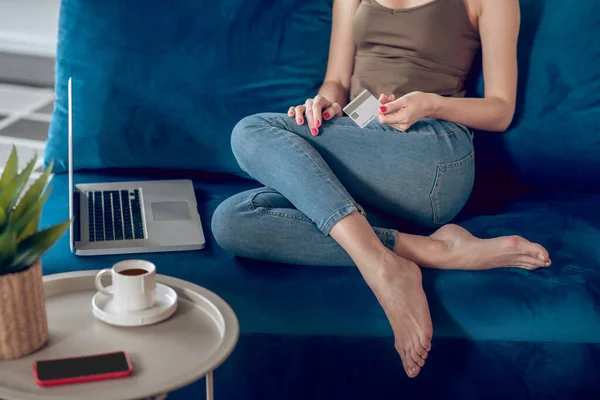 Крупним планом жінка сидить на дивані з ноутбуком — стокове фото