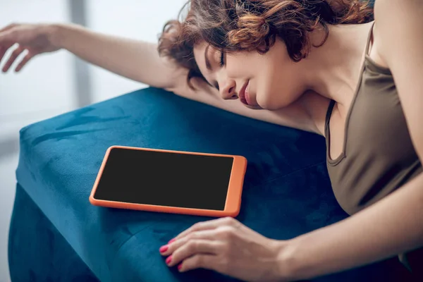 Mulher bonita dormindo no sofá com um tablet ao lado dela — Fotografia de Stock