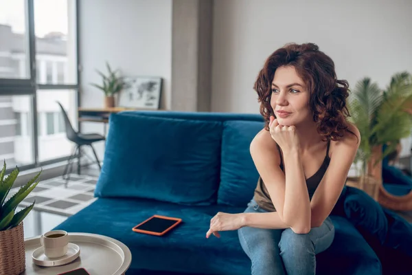 Mujer joven sentada con una vista reflexiva — Foto de Stock