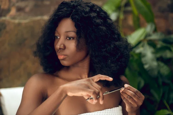 Wanita african Amerika yang cantik memotong ujung rambutnya dan terlihat bijaksana — Stok Foto