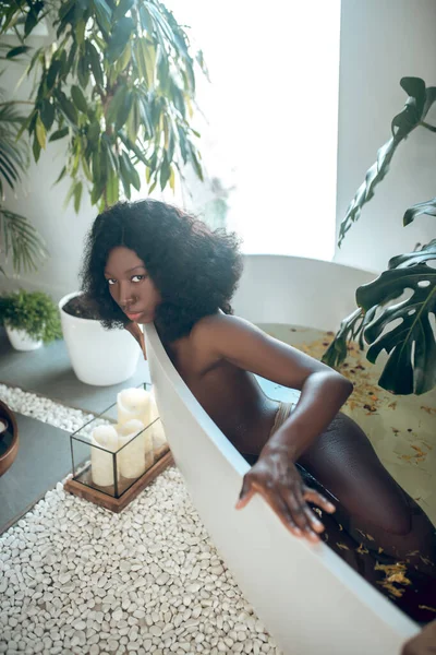 Тонкая темнокожая женщина расслабляется в ванной — стоковое фото
