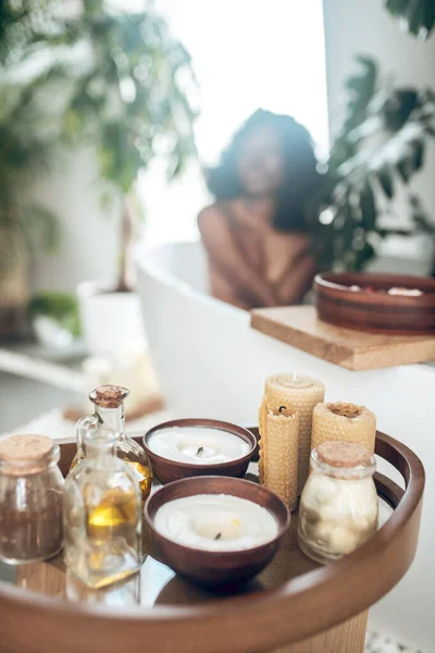 Темнокожая женщина расслабляется в ванной и моет свое тело — стоковое фото