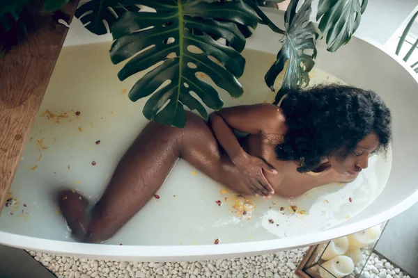 暗い肌の美しい裸の女性が風呂に寝そべって — ストック写真