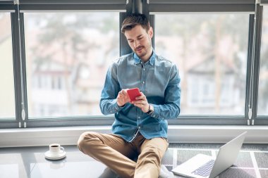 Ofiste çalışan koyu renk saçlı adam ve meşgul görünüyor.