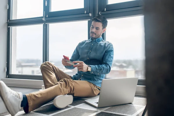 Joven hombre haciendo el pago en línea en su teléfono inteligente — Foto de Stock