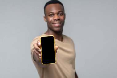 Elinde akıllı telefon ekranı olan adam ileri doğru uzandı