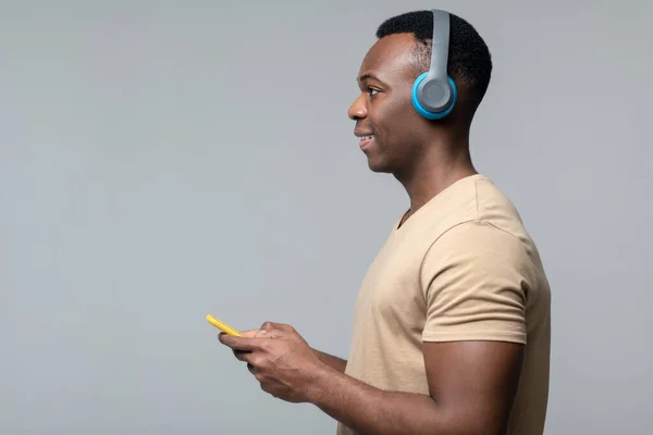 Hombre con smartphone en auriculares de lado — Foto de Stock