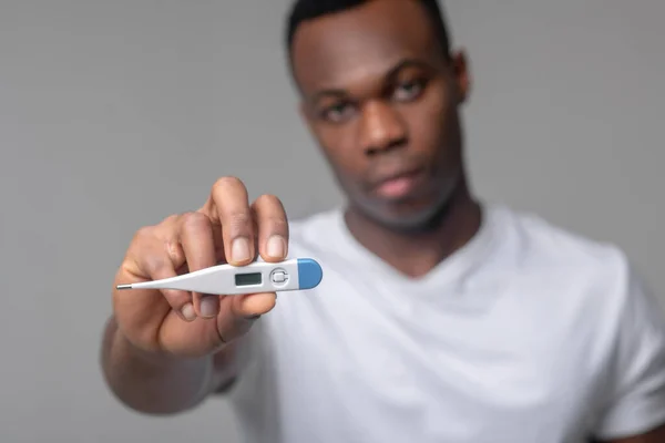 Man holding out thermometer to camera — Stock Photo, Image