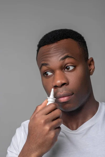 Triste afroamericano con spray medicinal cerca de la nariz — Foto de Stock