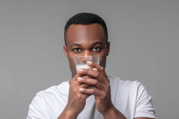 Afrykański amerykański trzymający szklankę mleka na poziomie twarzy — Zdjęcie stockowe