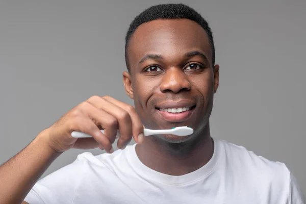 Afrykański Amerykanin ze szczoteczką do zębów w pobliżu ust — Zdjęcie stockowe
