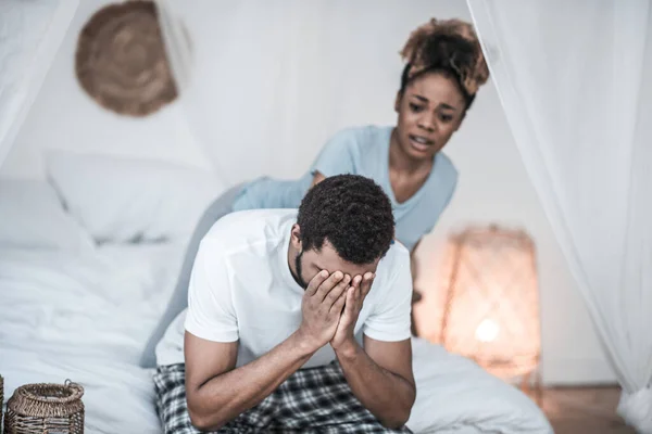 Hombre infeliz cubriéndose la cara con manos y esposa — Foto de Stock