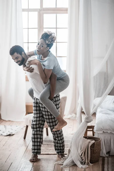 Dark-skinned man holding woman on his backous — Stock Photo, Image